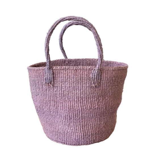 Woven purple basket on a wooden surface with a white wall background