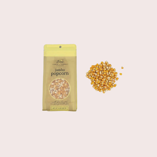 Jumbo popcorn package with unpopped kernels on a light gray background
