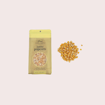 Jumbo popcorn package with unpopped kernels on a light gray background